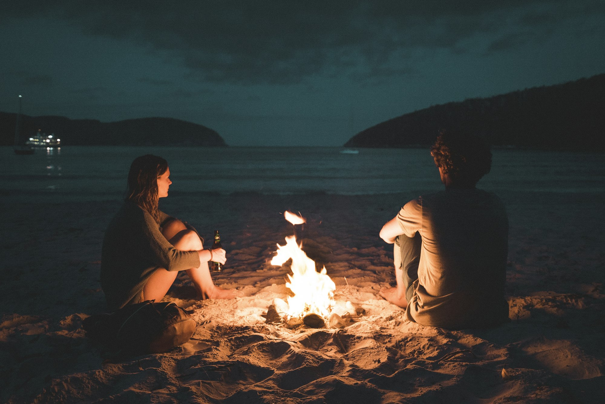 Couple by a beach campfire